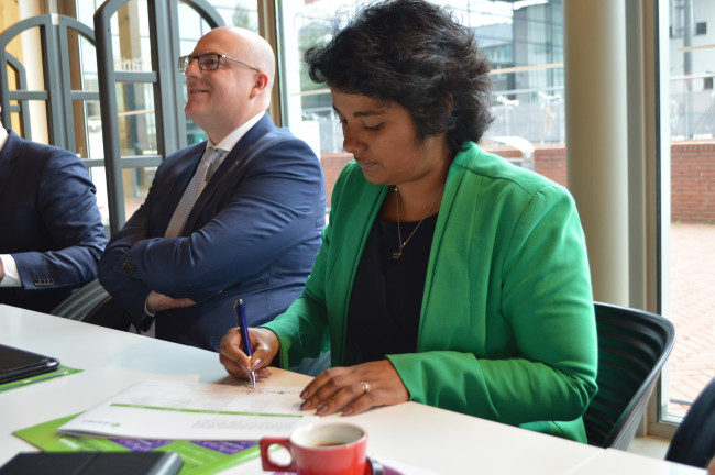 VVD-wethouder Irene Korting van economische zaken ondertekent het coalitieakkoord.