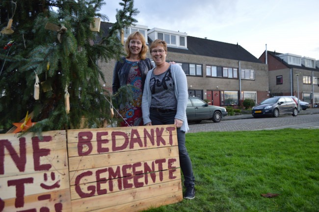 De buurvrouwen Karin Spekkink en Yvonne de Bree bij de kerstboom.