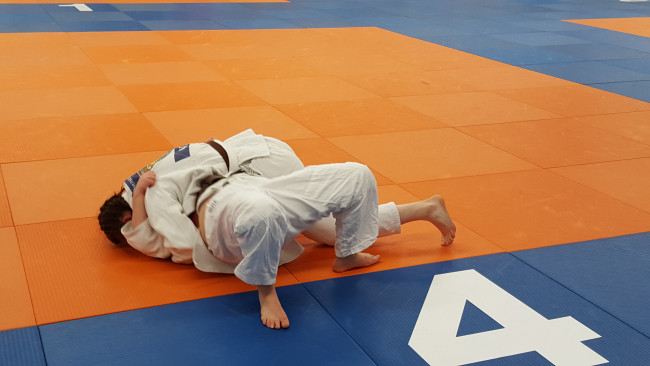 Kayleigh heeft tegenstander Proctor in de houdgreep.