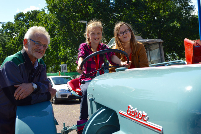 Henk Grijsen met enkele belangstellende kinderen tijdens het julifeest in Swifterbant.