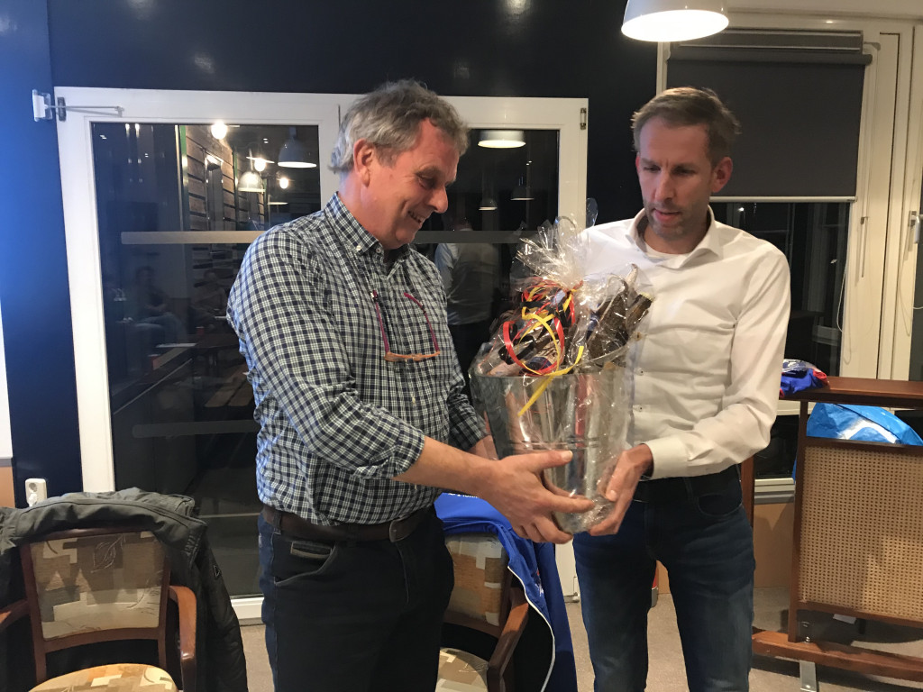 Voorzitter Jan Jonkers (l) ontvangt een afscheidscadeau van secretaris Edwin Knol (r) tijdens de jaarvergadering.