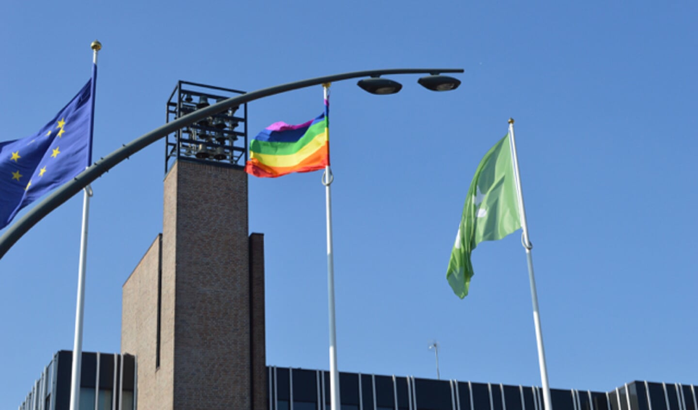 Vlag voor Coming Out Day hangt bij gemeentehuis ondersteboven