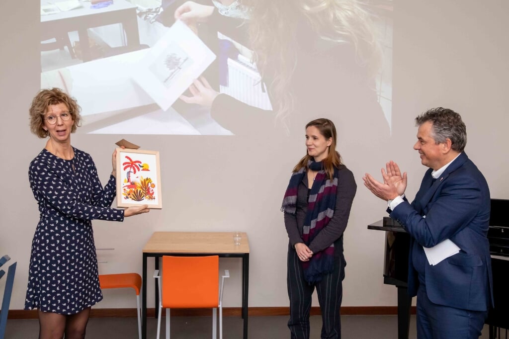 Wethouder Irma van der Sloot ontvangt een unieke kleurenzeefdruk uit handen van kunstenares/docent Kirsten Offringa en Quintusdirecteur Hendrik Jan Houtsma.
