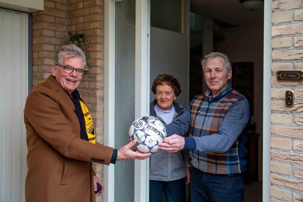 Henk Albers (r) overhandigt een bal aan DOS-voorzitter Arend Runia.