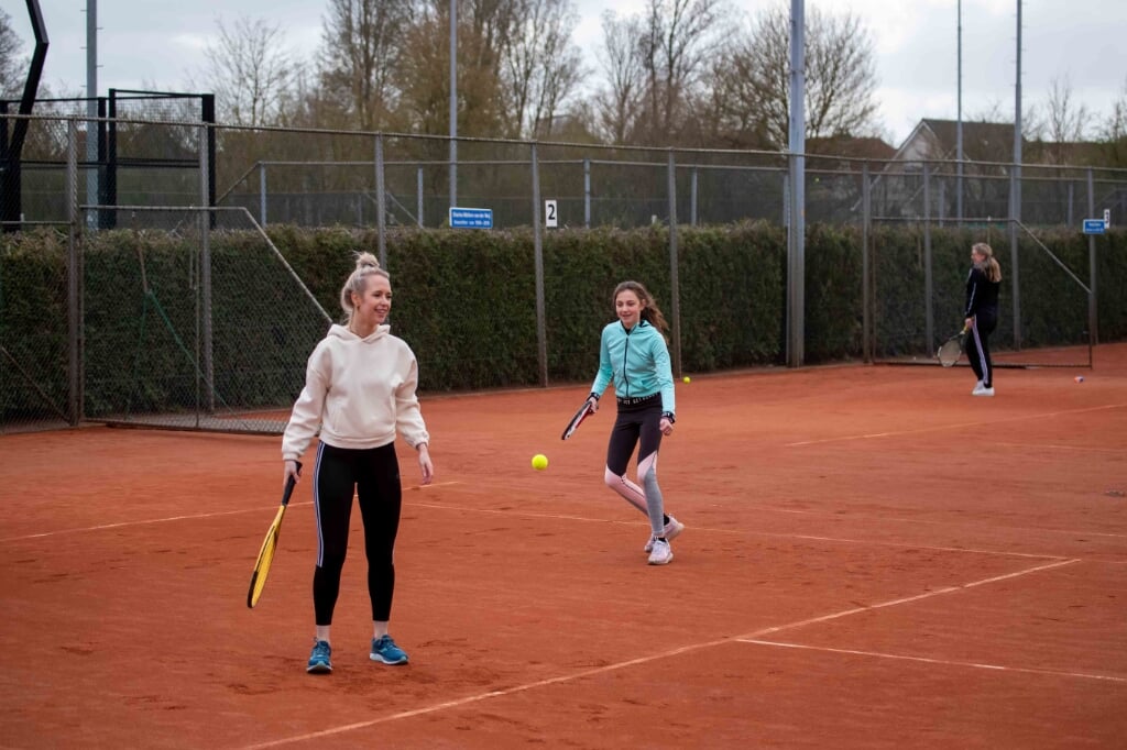 Twee deelnemers genieten van hun kennismaking met tennis bij KJLTC. 