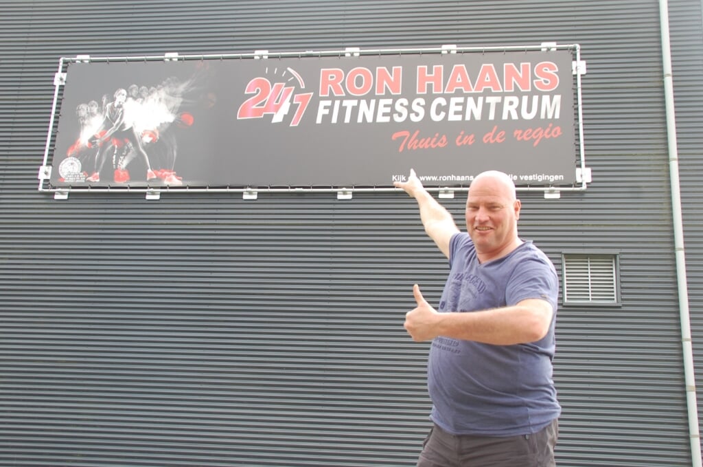 Ron Haans bij het bord van zijn nieuwe sportschool. 