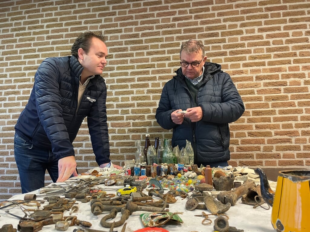 Barneveld en Van Lente kijken naar de gevonden voorwerpen.