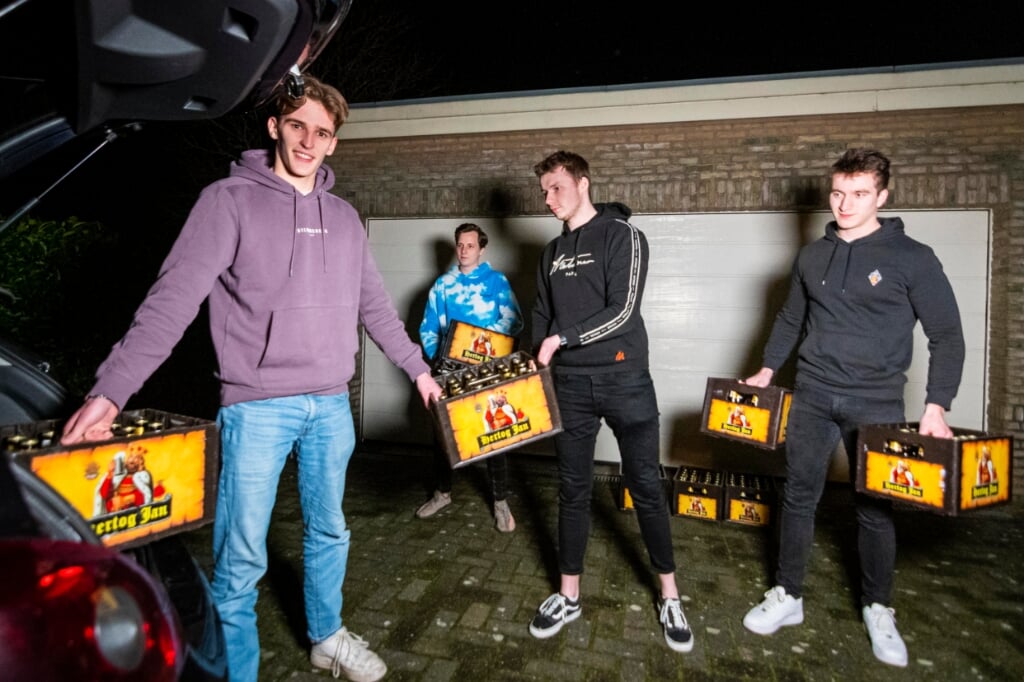 De vier vrienden Robert Hofker, Thimo Boven, Robin Visschedijk en Hessel van Dalen (vlnr) laden vrijdagavond hun auto vol met kratjes bier