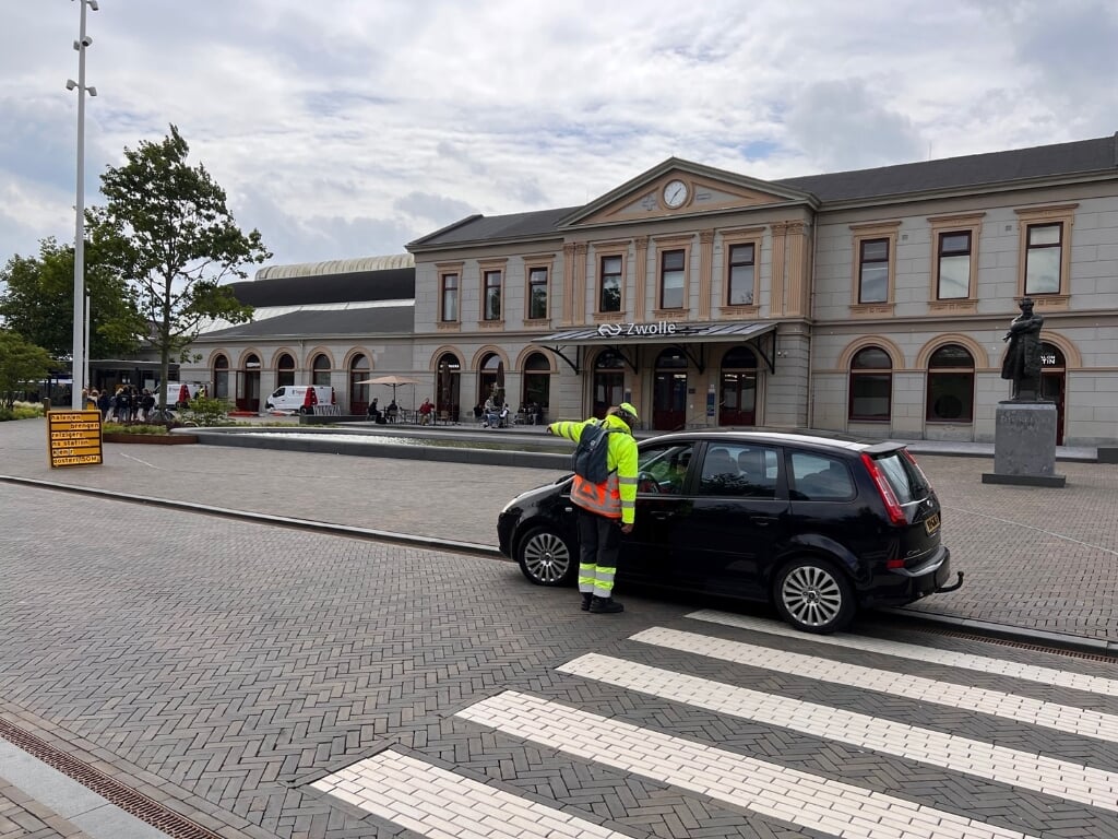 Een verkeerscoach leidt automobilisten naar de nieuwe Kiss and Ride aan de Oosterlaan.