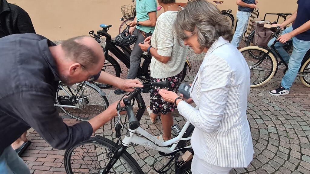 Wethouder Gerdien Rots krijgt een kastje op haar fiets gemonteerd.  