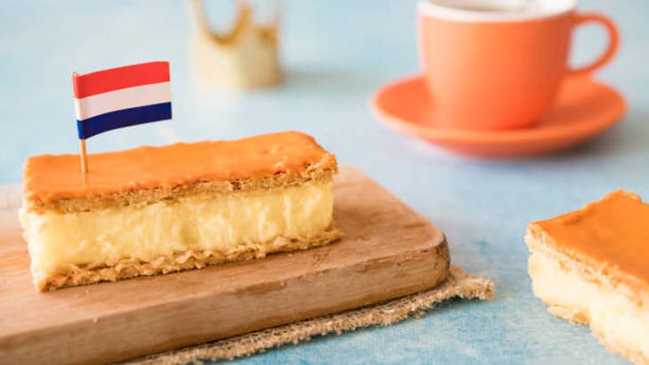 Dutch breakfast setting for National event Kings Day on the 27th of April, in The Netherlands. Orange tompouce, Cup of coffee, Dutch flag and crown