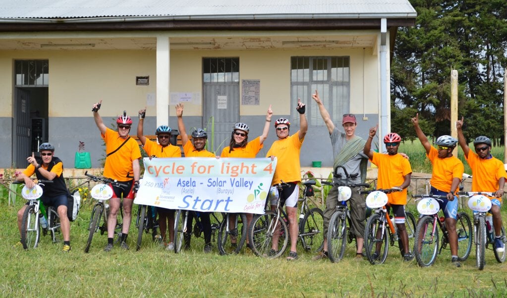 Start Cycle for light 2015 bij medische hulppost in Assela. (Noud Heuvelmans 2e van links met helmcamera en Samson 4e van links)