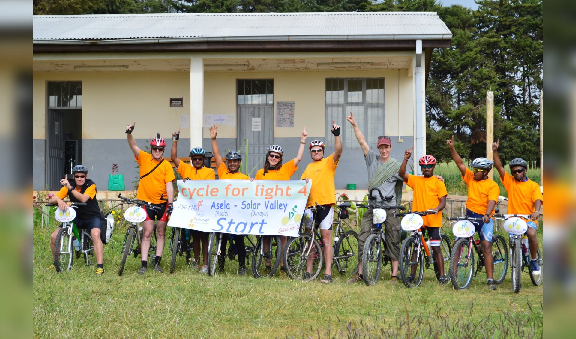 Start Cycle for light 2015 bij medische hulppost in Assela. (Noud Heuvelmans 2e van links met helmcamera en Samson 4e van links)