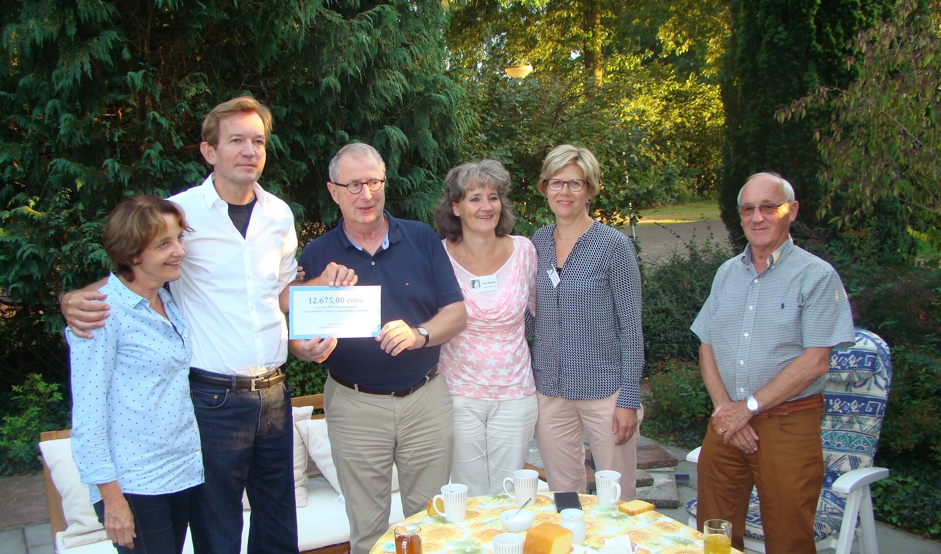 Othon Eijsbouts overhandigd samen met zijn vrouw de check aan  een aantal vrijwilligers van het Bijna Thuis Huis 