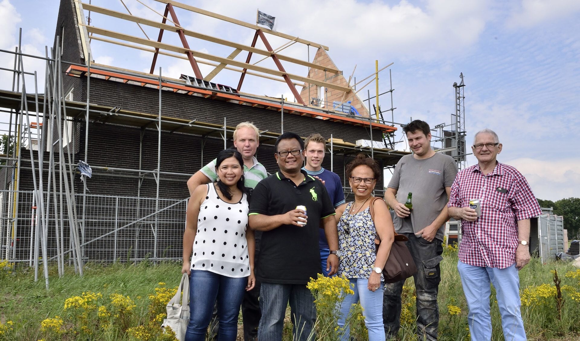 Familie van der Veen samen met de bouwers voor hun huis in aanbouw