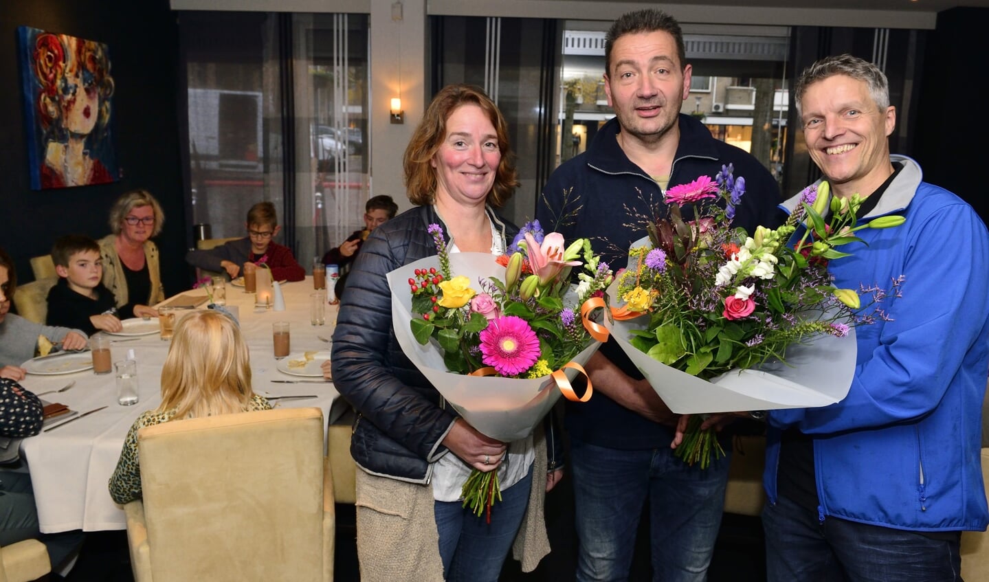 Karin Teulings (rechts) en Leon Spierings (rechts) krijgen de bloemen uit handen van Arrold van den Hurk, Leon Spierings en Albert Broks serveren de pannenkoeken