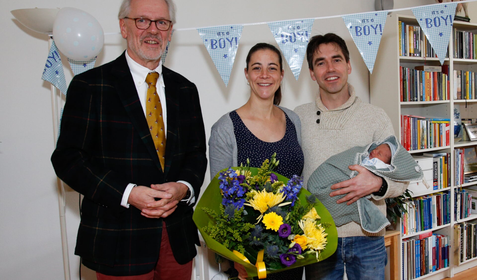 Burgemeester Hans Gaillard samen met de trotse ouders Roos en Bram en baby Pim op de foto 