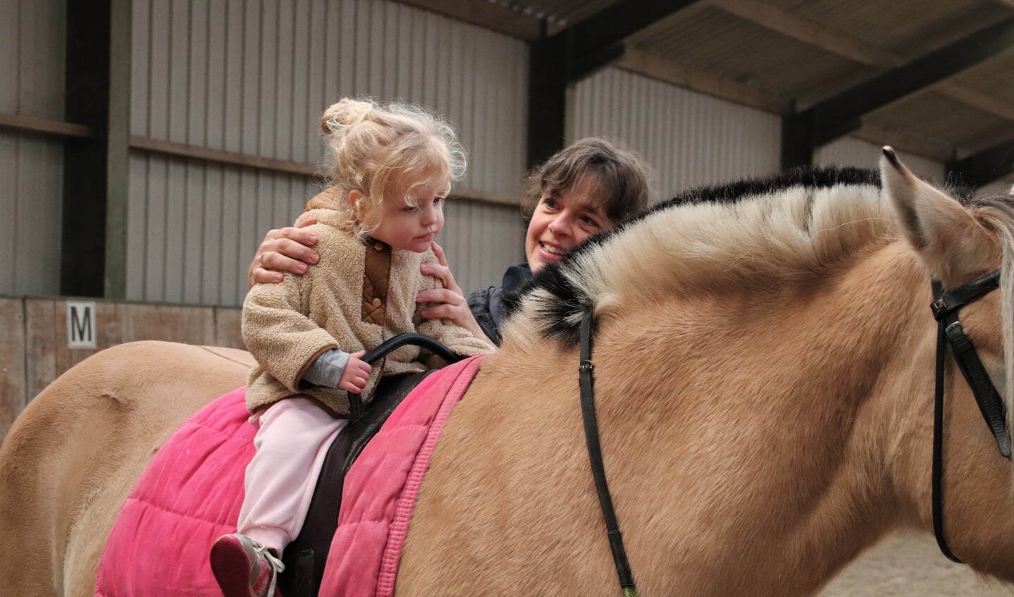 De driejarige Mare rijdt voor het eerst op een pony