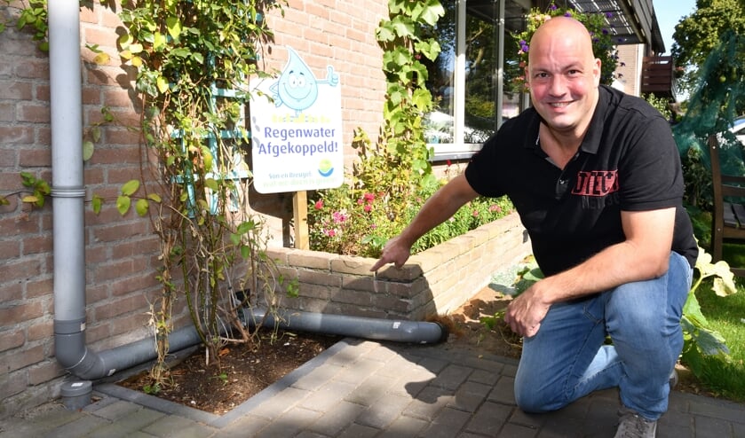 Patrick in de voortuin wijzend naar 'zijn afkoppelsysteem' (Archieffoto) | Fotonummer: b9aa04