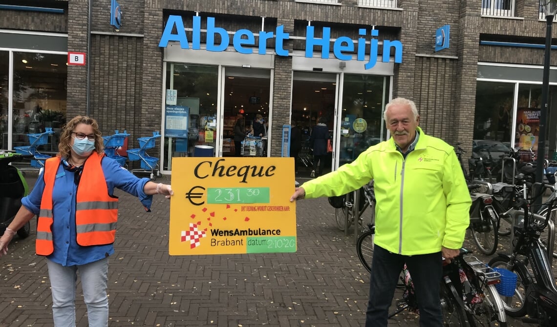 De cheque wordt overhandigd aan de vrijwilliger van WensAmbulance Brabant