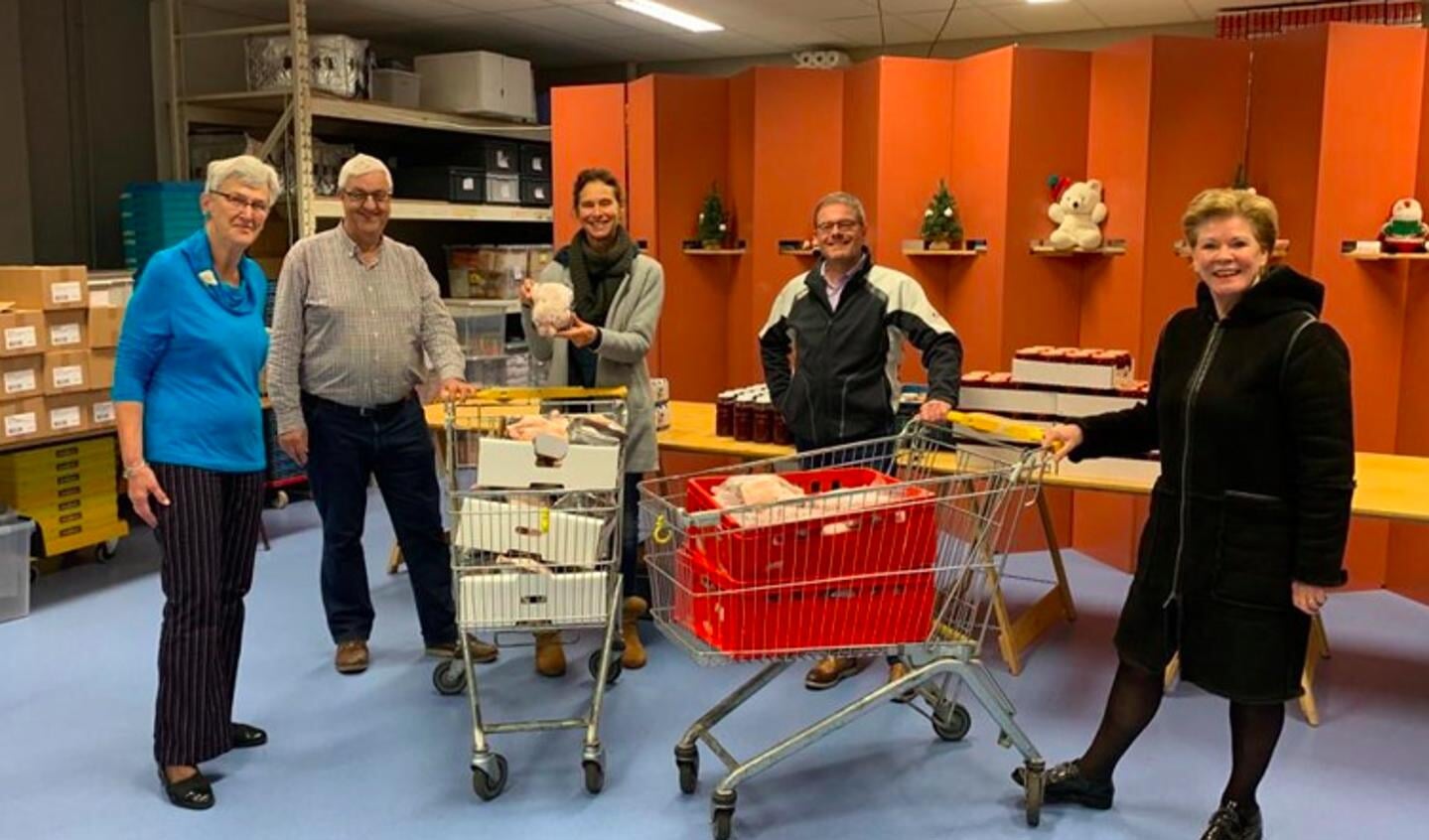 Een vertegenwoordiging van de leden van Rotaryclub Boxtel - Oirschot - Haaren overhandigt 100 rollades en braadkippen aan Frans en Mia van Rosendaal en Jan van Loenhout van de Voedselbank Best e.o.