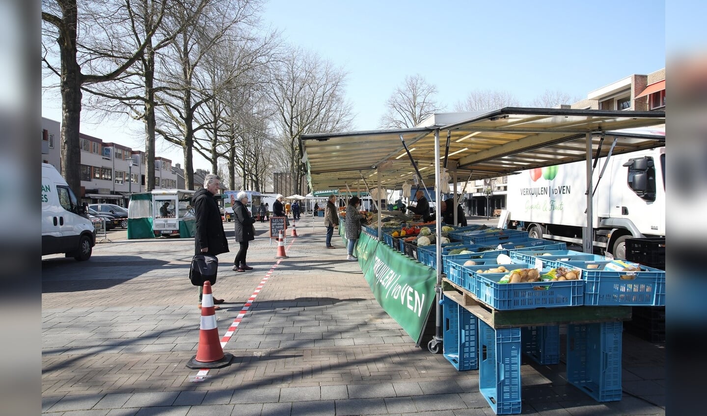 Bezoekers weekmarkt wachten achter de markering
