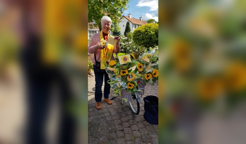 Bestuurslid Anne van Hoorn met de zonnebloemen voor de gasten en de vrijwilligers