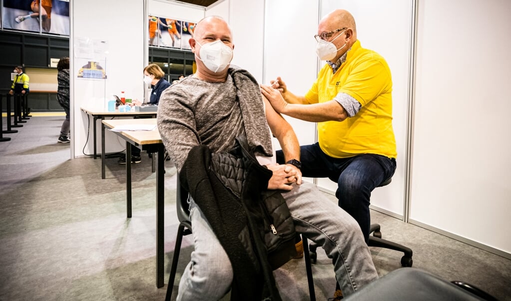 Thieu Smeets, directielid van de GGD Brabant Zuidoost, zet een van de eerste vaccinaties tijdens de start van het inentingsprogramma tegen het coronavirus