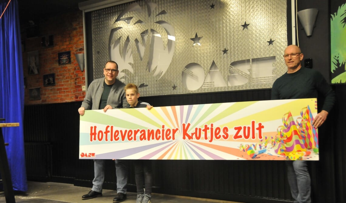 <p>Harm-Jan (l) met zoon Luc en Marijn (r) houden het caranvalsbord vast dat als eerste is gemaakt en nu nog steeds wordt opgehangen</p>