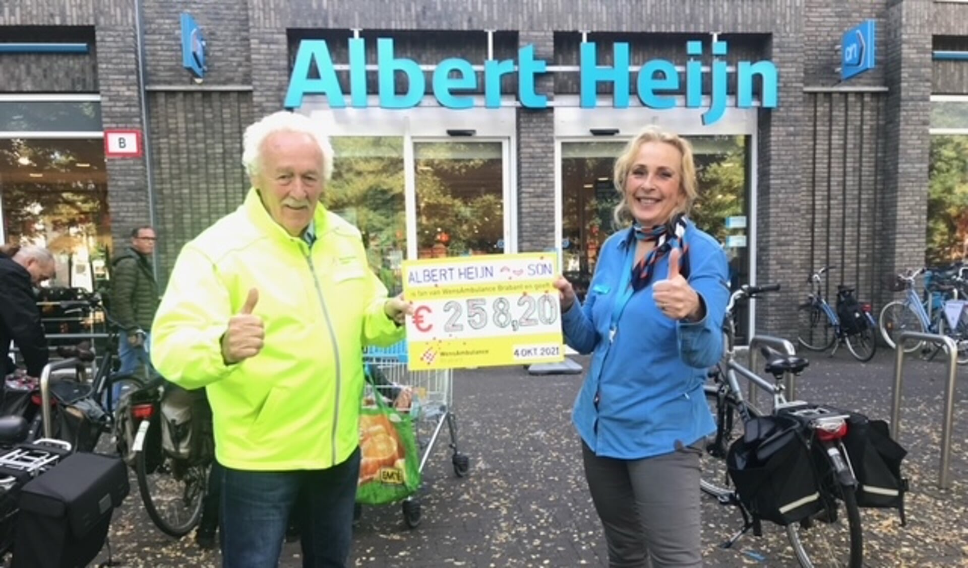 Werkneemster van Albert Heijn overhandigt een symbolische cheque aan vrijwilliger Barry 
