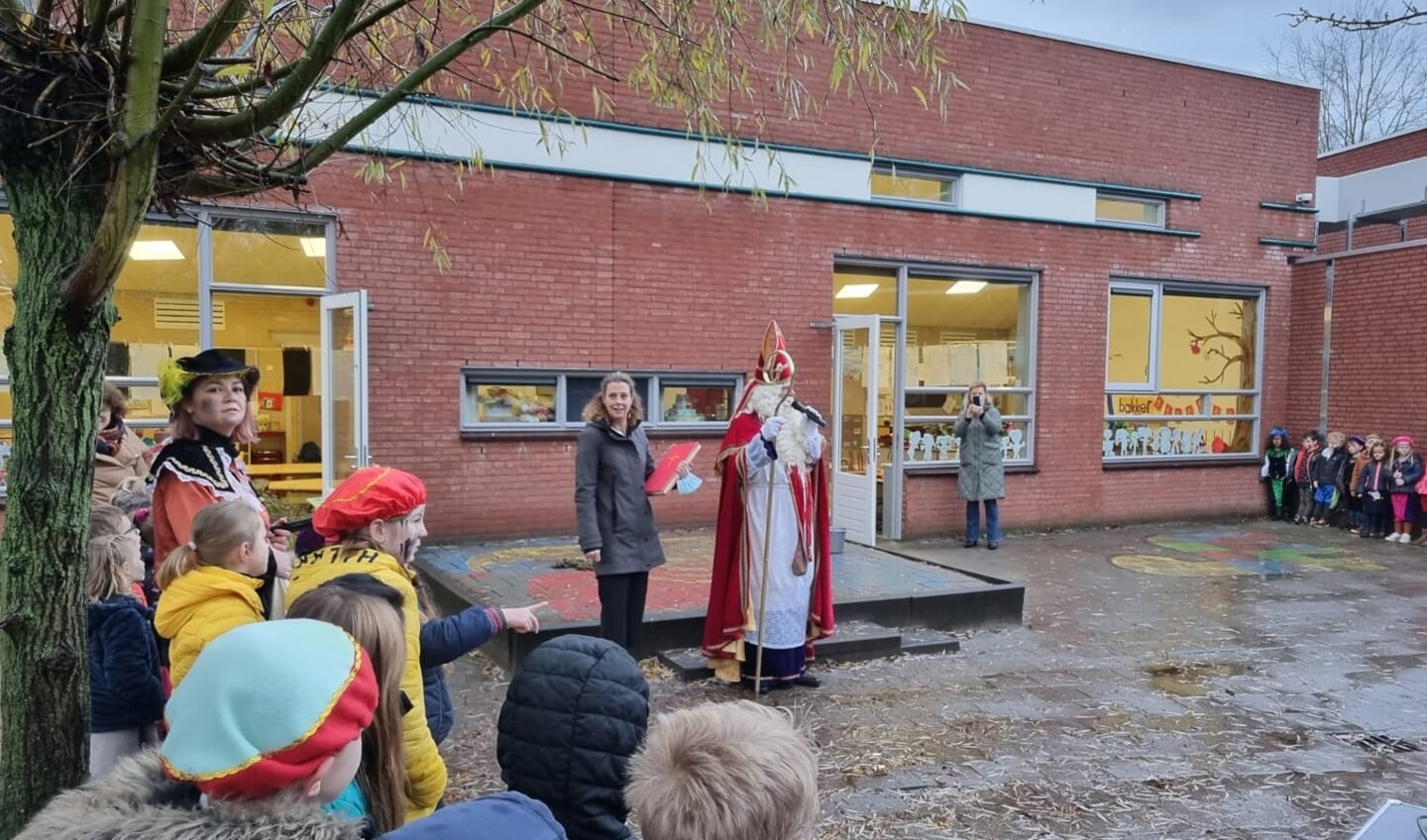 Directeur Lidwien Storimans naast Sinterklaas op het schoolplein