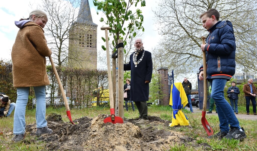 Juka en Luuk helpen burgemeester Gaillard mee om de Anne Frankboom te planten