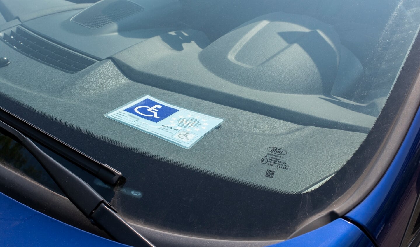 De gehandicaptenparkeerkaart op het dashbord van een auto