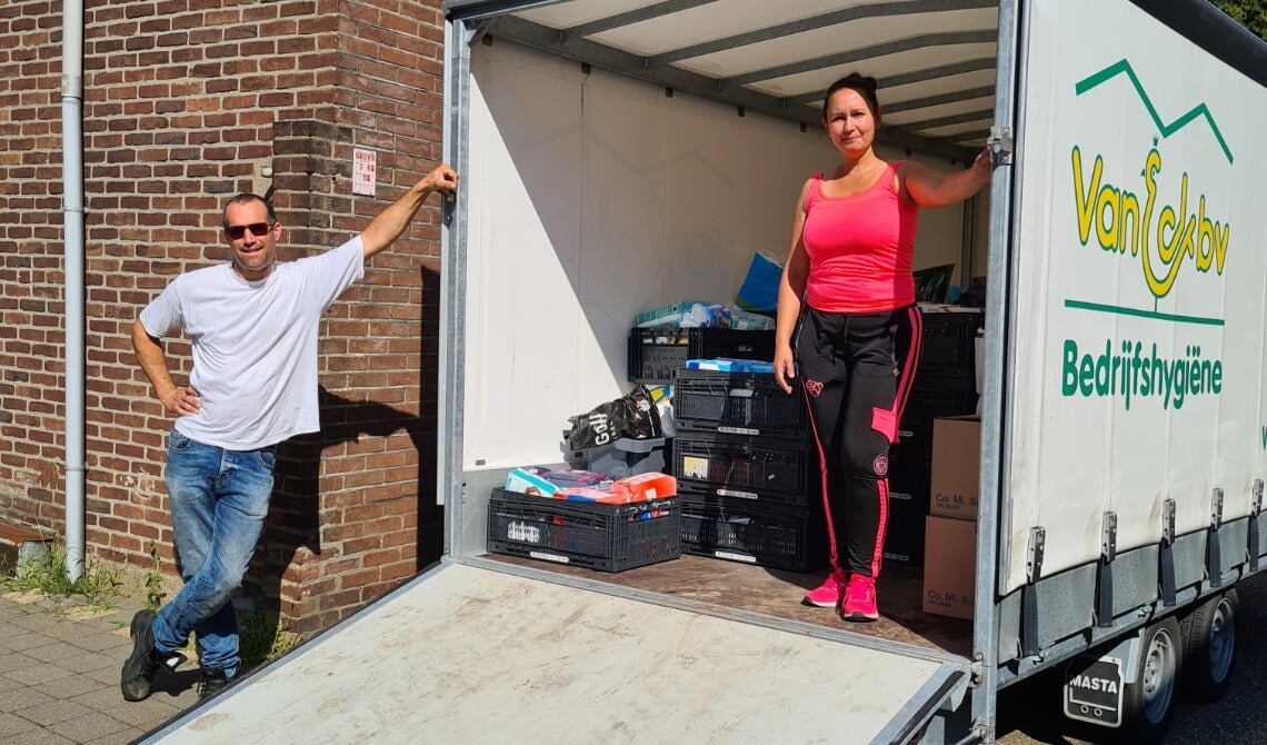 <p>Gilbert (l) en Sarah (r) bij de vrachtwagen die volgeladen werd met goederen voor Limburgers</p>