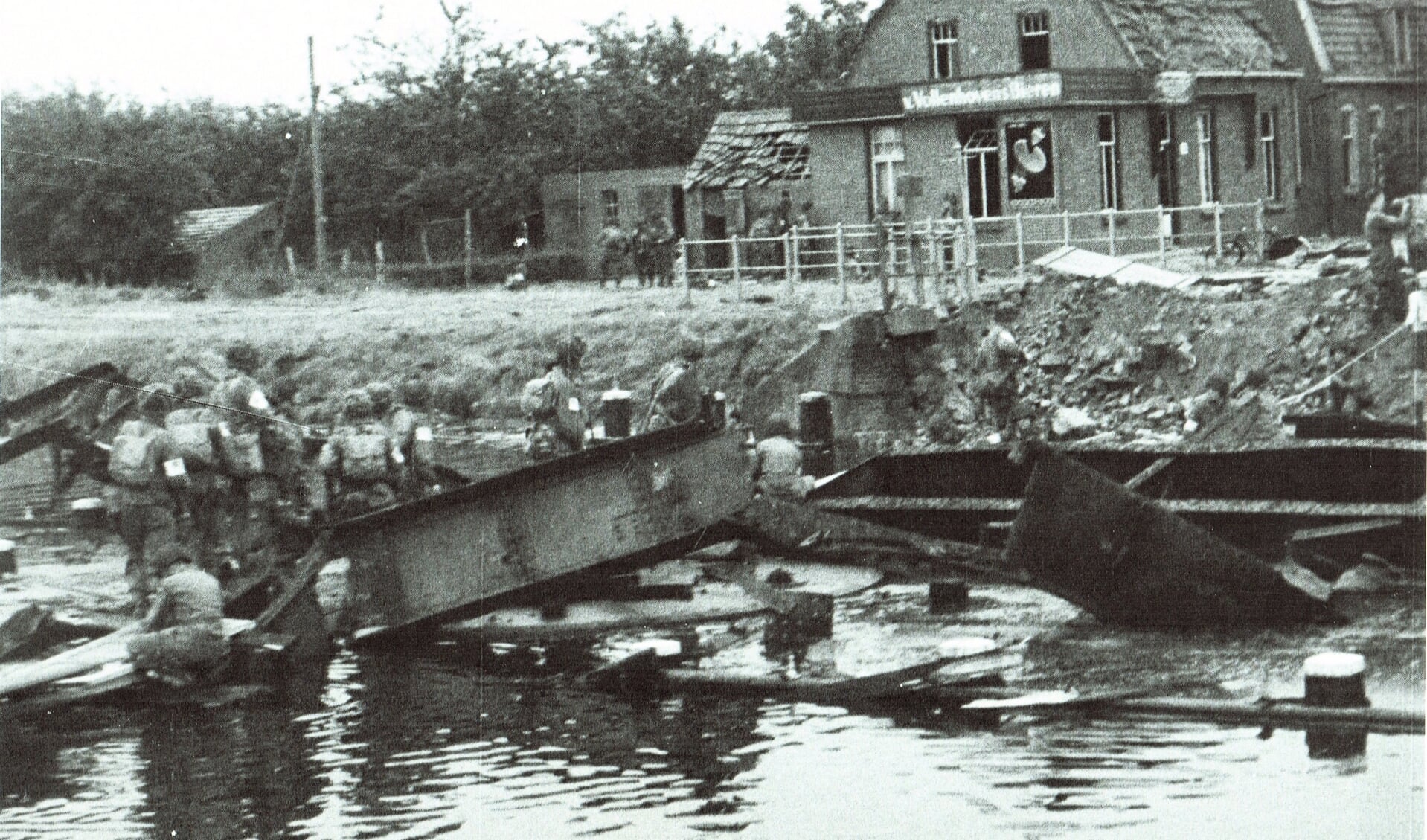 de vernielde brug over het kanaal, op 17 september 1944 door de Duitsers opgeblazen. Aannemer Lavrijssen had gauw al planken aangeleverd voor een droge oversteek naar Eindhoven
