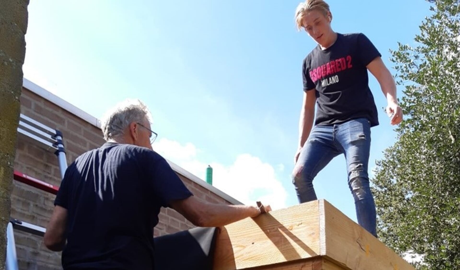 Links klusvrijwilliger Jan Verhagen, op het dak Michael Maas van Houthandel Maas. Mari van Kemenade ontbreekt op de foto
