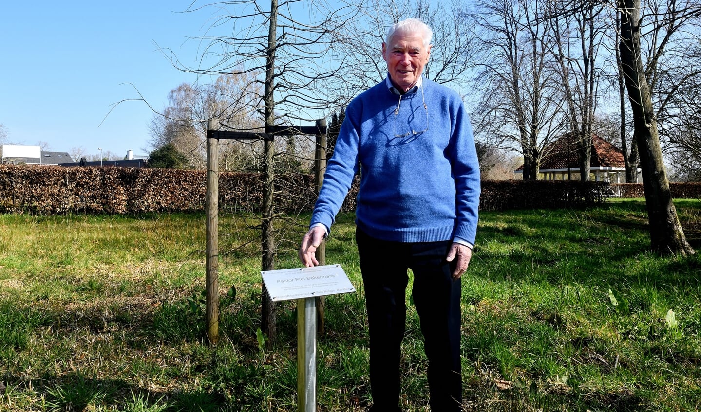 Piet Bakermans staat voor de boom die door de gemeenschap aan hem is geschonken