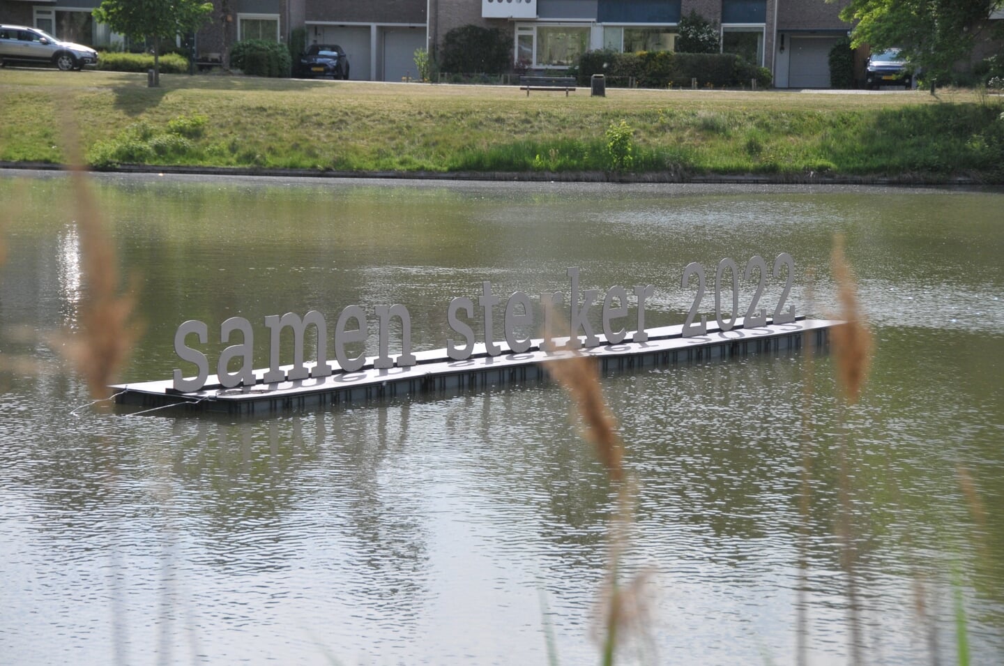 De letters 'samen sterker' op de vijver