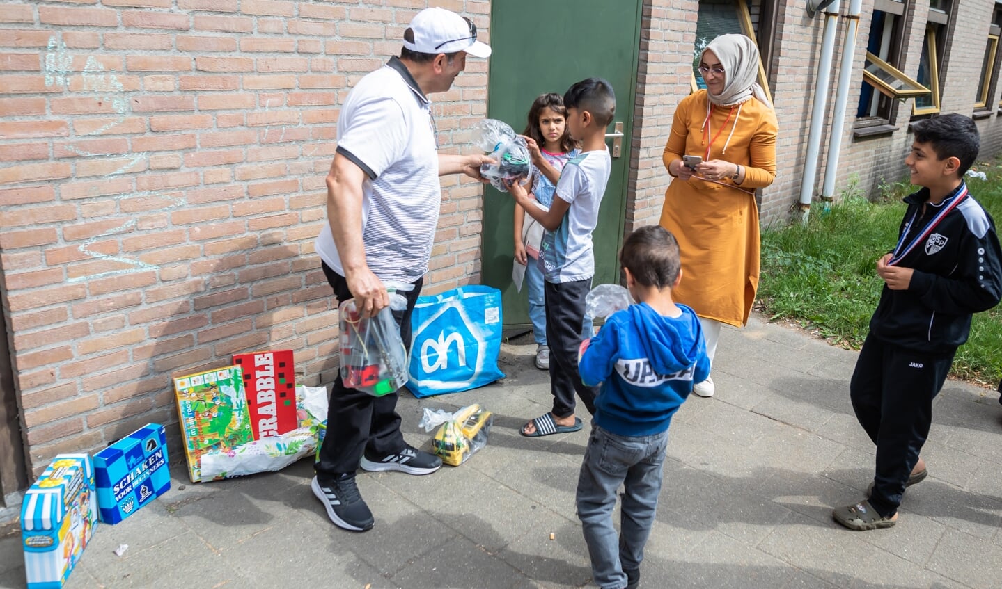 Het speelgoed wordt uitgereikt aan de kinderen in het AZC