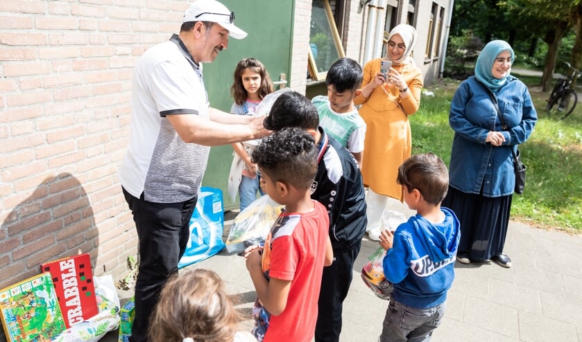 Het speelgoed wordt uitgereikt aan de kinderen in het AZC