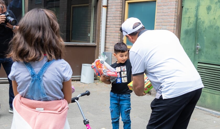 Het speelgoed wordt uitgereikt aan de kinderen in het AZC