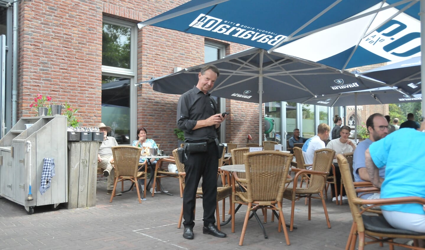 Koos Vlemmix  aan het werk op het terras van café restaurant De Zwaan