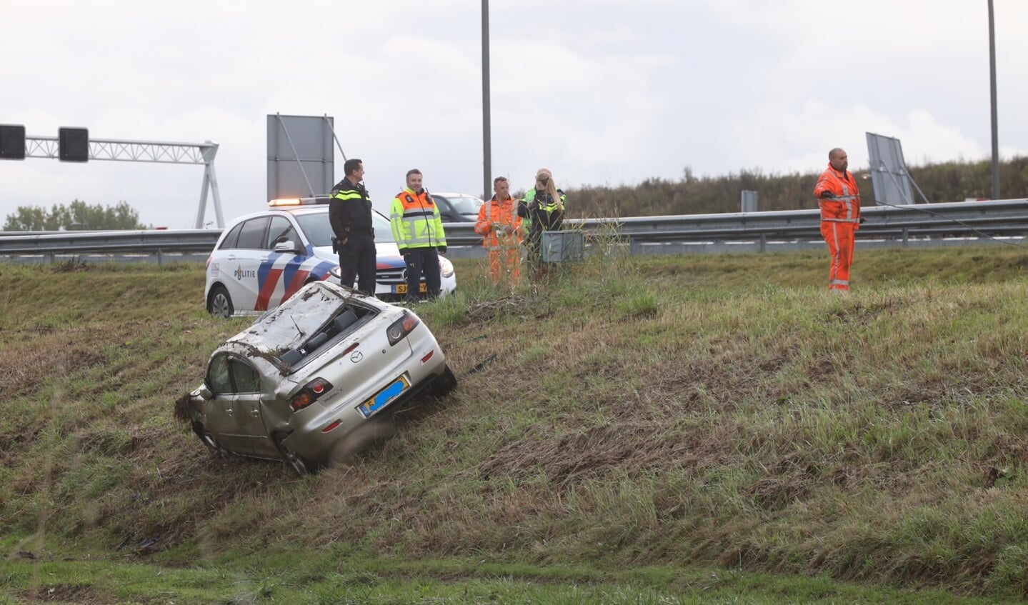 Auto op zijn kop in greppel langs snelweg A50 bij Son en Breugel