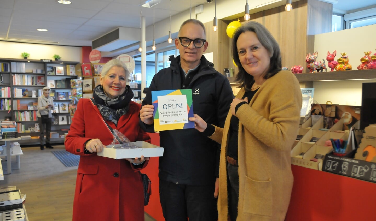 Maaike van Oosterhout van boek en kantoorhandel de Traverse ontvangt het bord van Marianne Wagemans (Sonenergie) en wethouder Steven Grevink