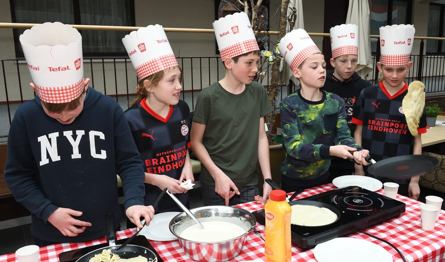 Leerlingen in de "open keuken" pannenkoeken aan het bakken
