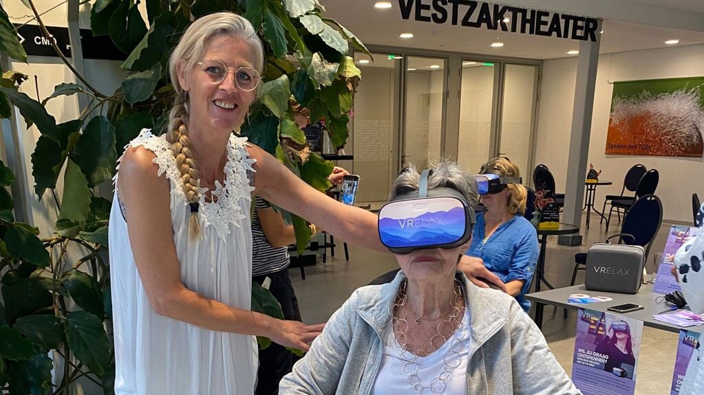 Marsja (links, vrijwilliger) laat mevrouw kennismaken met de VR bril.