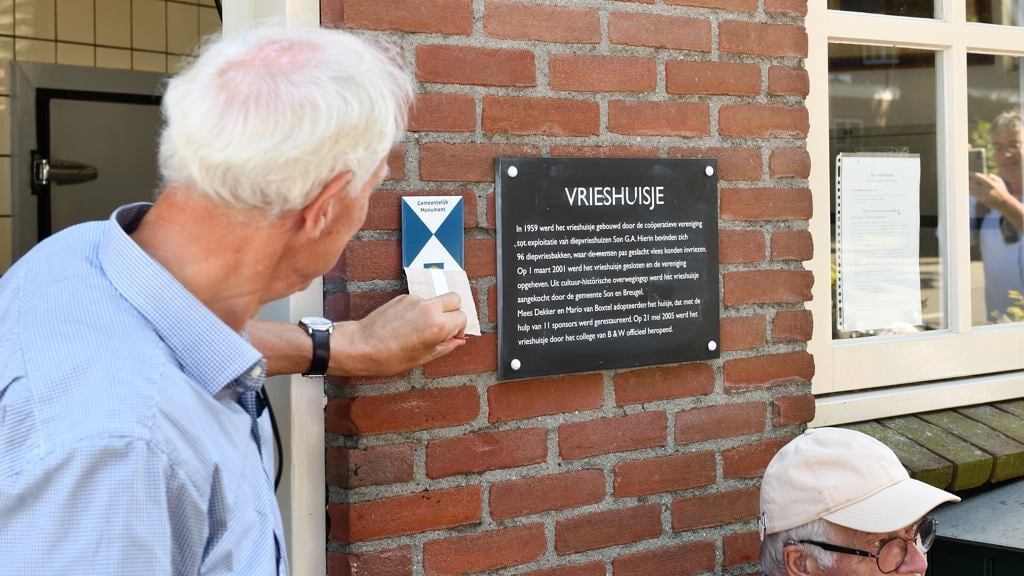 Wethouder Boersma onthult het monumentenschildje bij het vrieshuisje