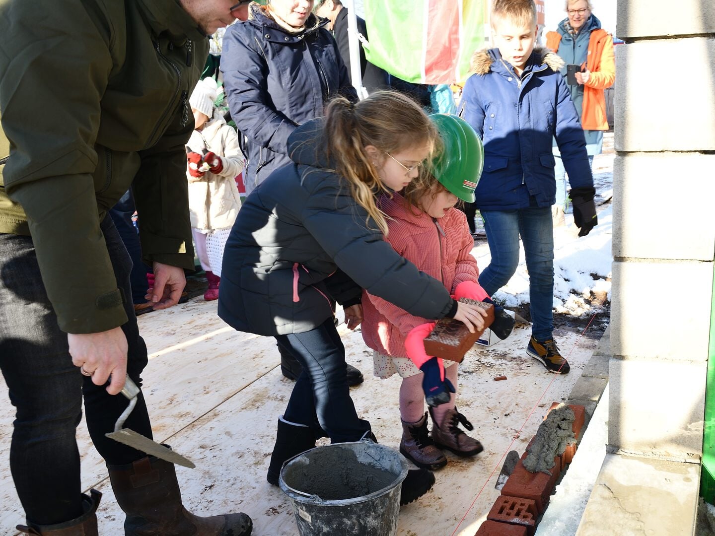 Tess en Sophie metselen de eerste steen voor nieuwbouw van hun school