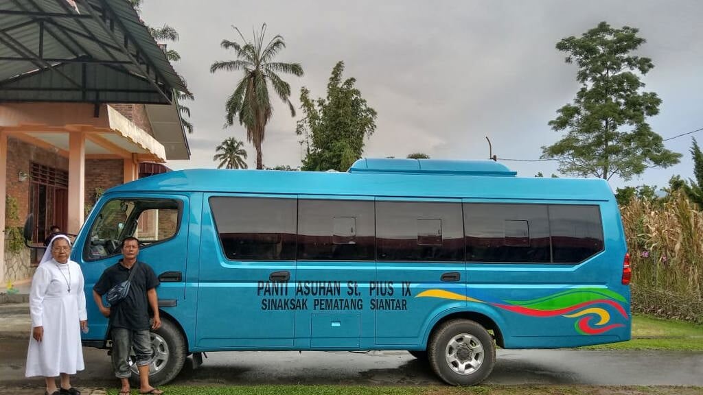 De nieuwe bus voor het weeshuis Panti Puis op Sumatra van stichting Harapan