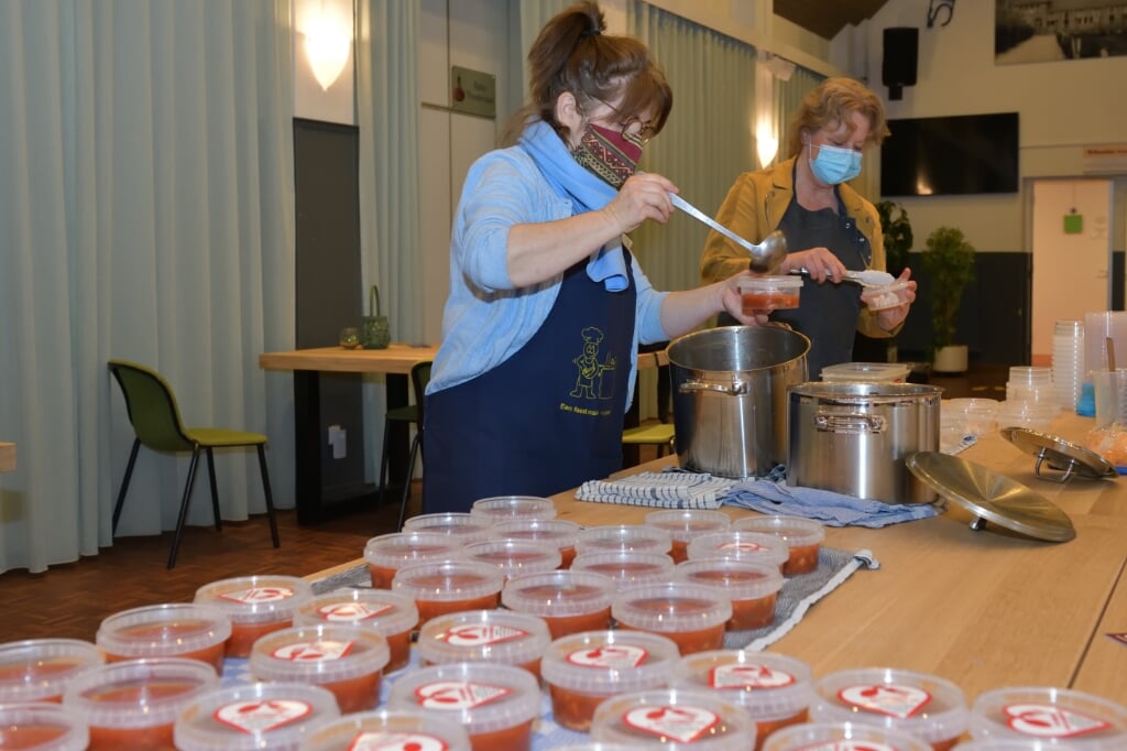 Gerda (voorgrond) en Rietta bezig met het vullen van de soepbakjes